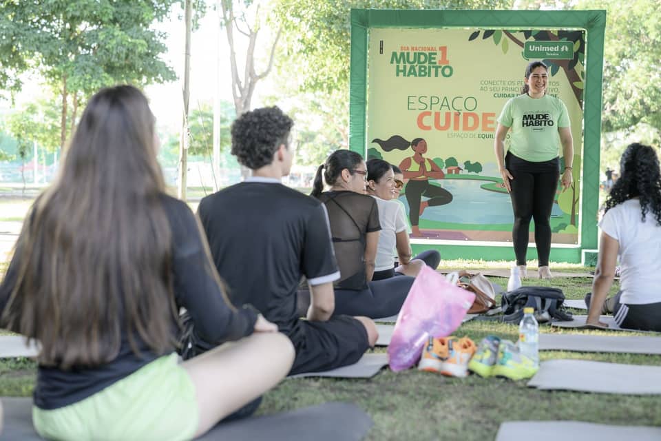 Público sentado em esteiras ao ar livre durante ativação de marca em parque