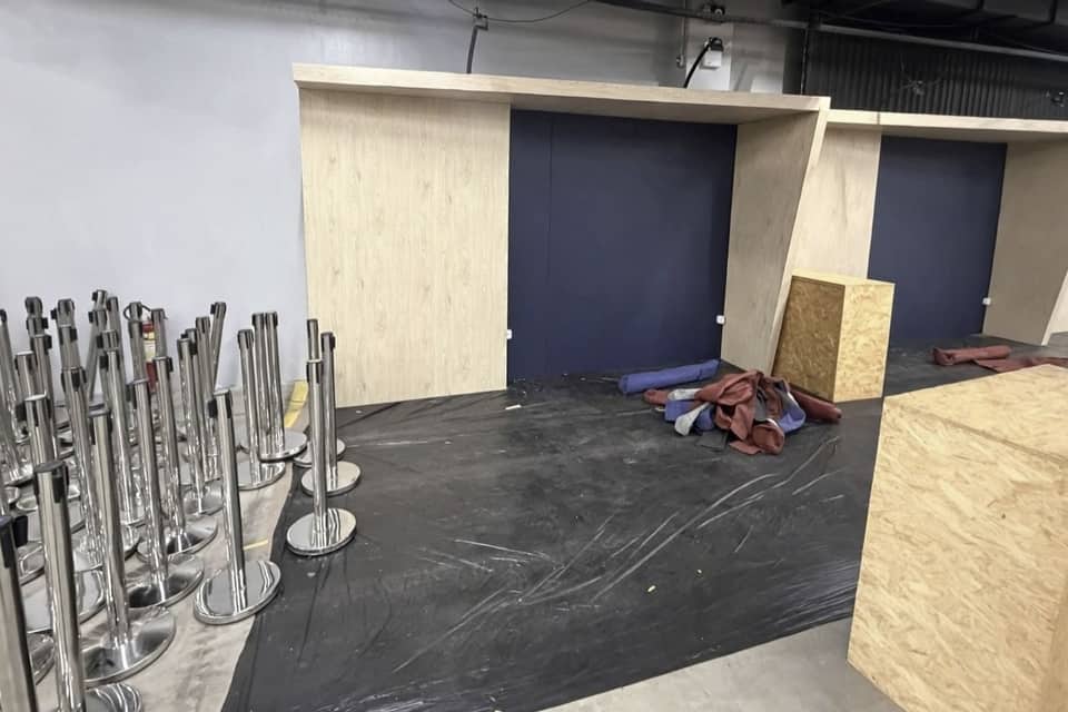 Estrutura de madeira crua de um stand em montagem dentro de um pavilhão de feira